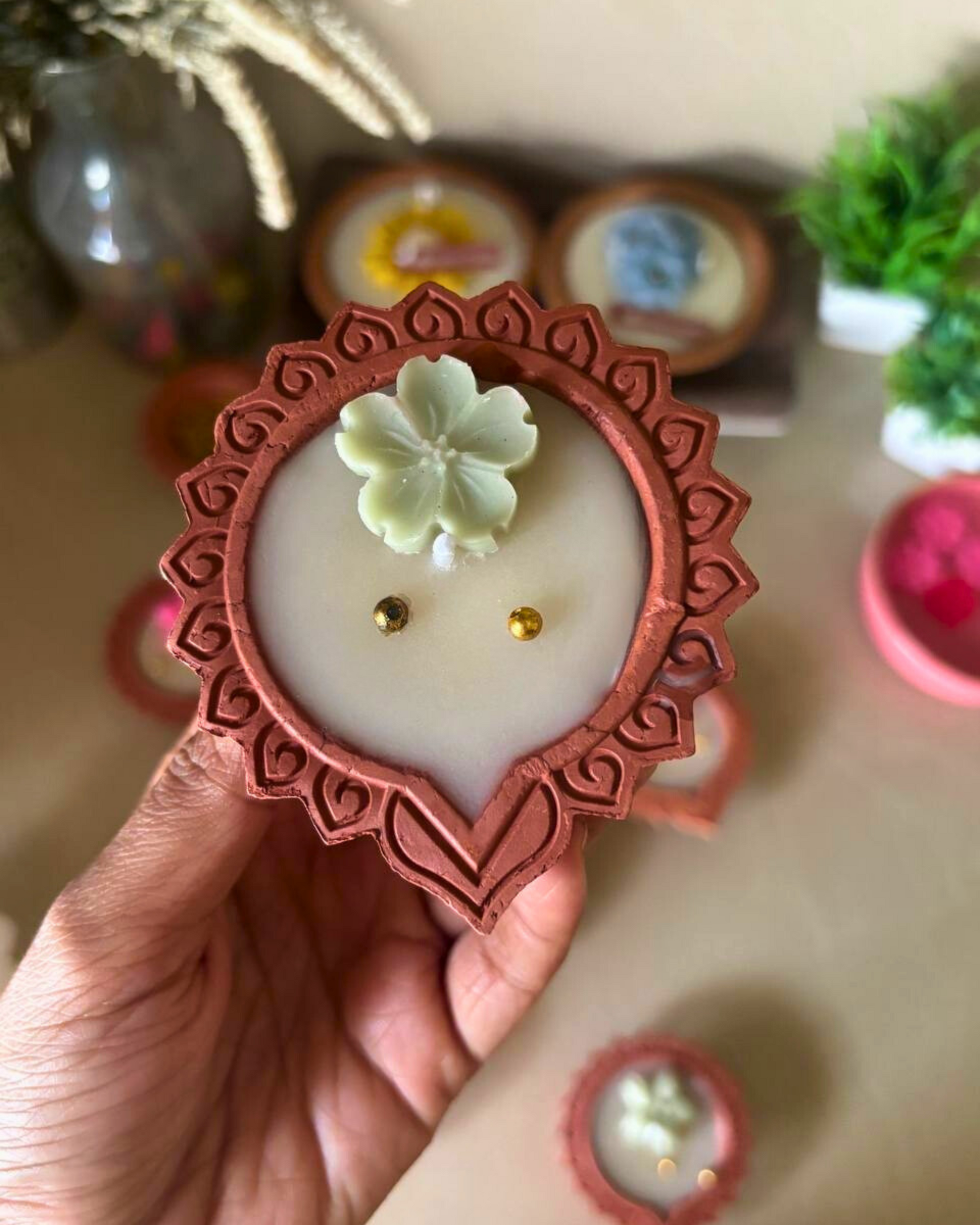 Eco-friendly soy wax floral diya candle with decorative flower detailing.
