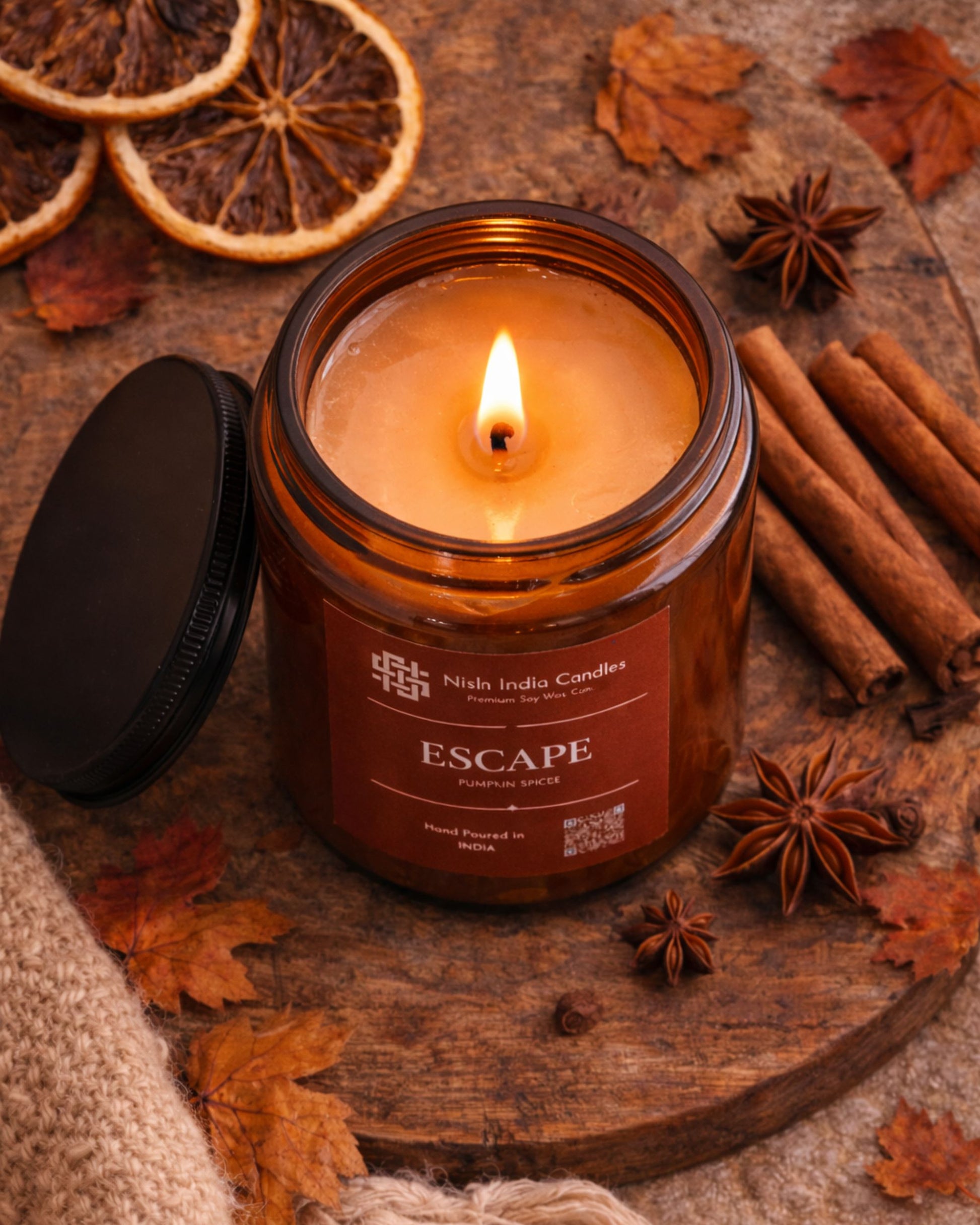 Escape Pumpkin Spice scented soy candle in amber jar placed on rustic wooden surface with fall decor elements creating a cozy seasonal ambiance.
