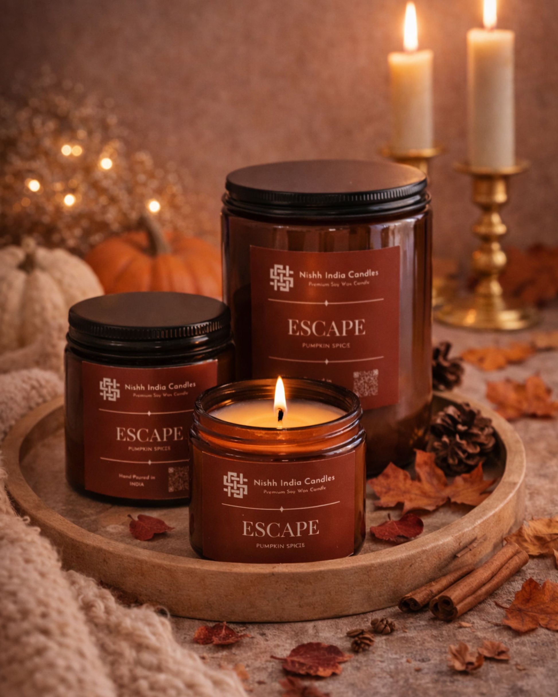 Nishh India Pumpkin Spice soy candle styled in fall inspired decor with rustic textures and warm tones for cozy home fragrance ambience.