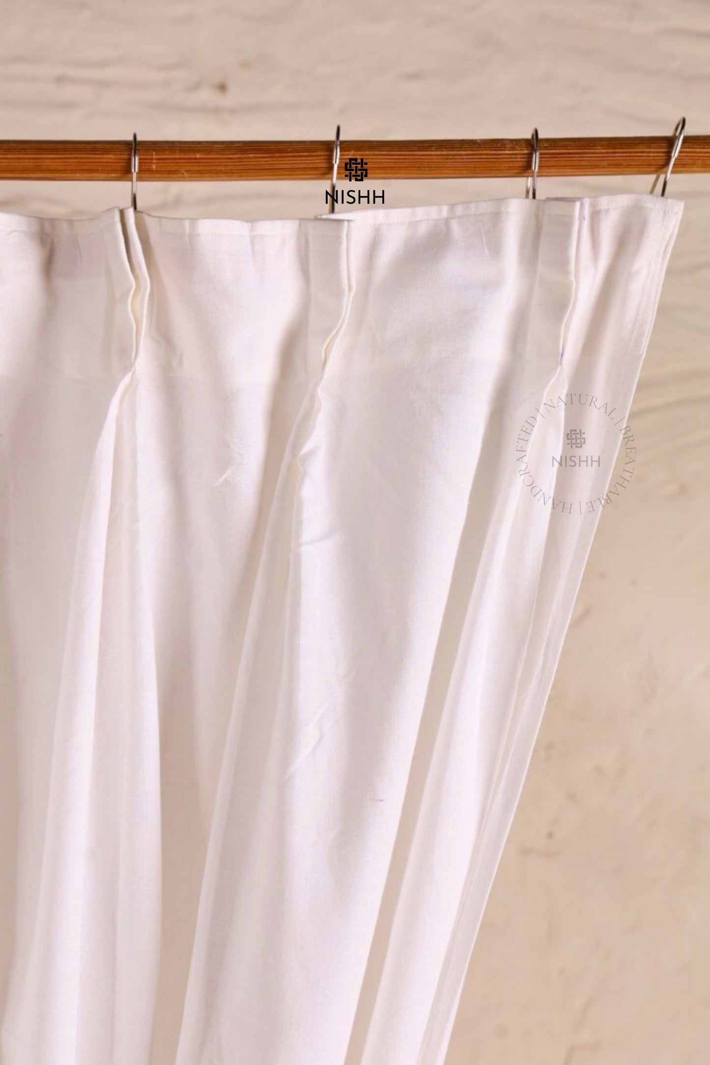 Close-up of handcrafted double pinch pleat detailing on linen curtains