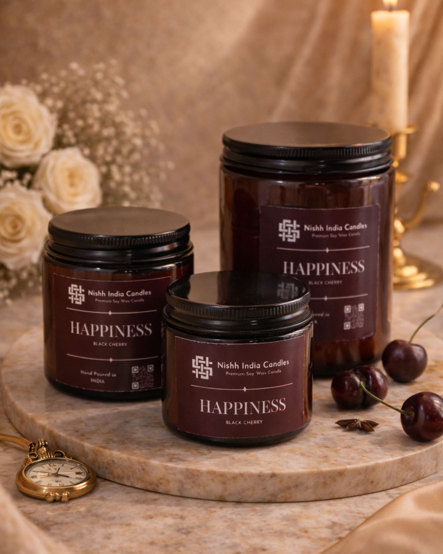 Top view of Nishh India Happiness Black Cherry scented soy candle lit in amber glass jar, styled with cherries and warm luxury home decor setting.