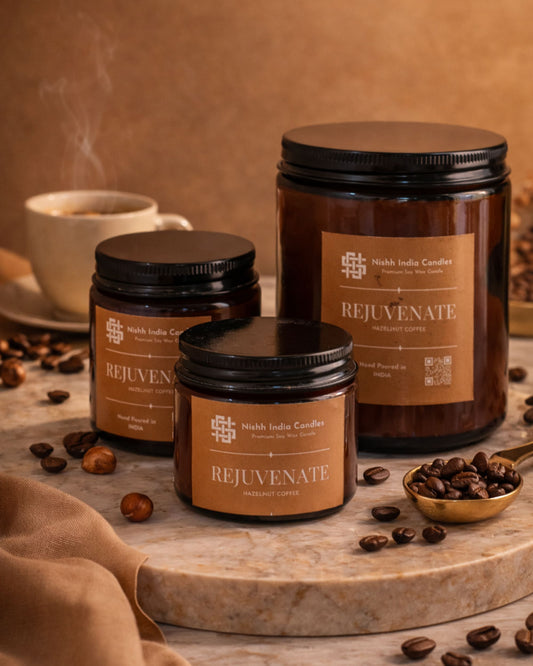 Nishh India Rejuvenate Hazelnut Coffee soy candle collection in multiple amber jar sizes displayed in luxury warm setup