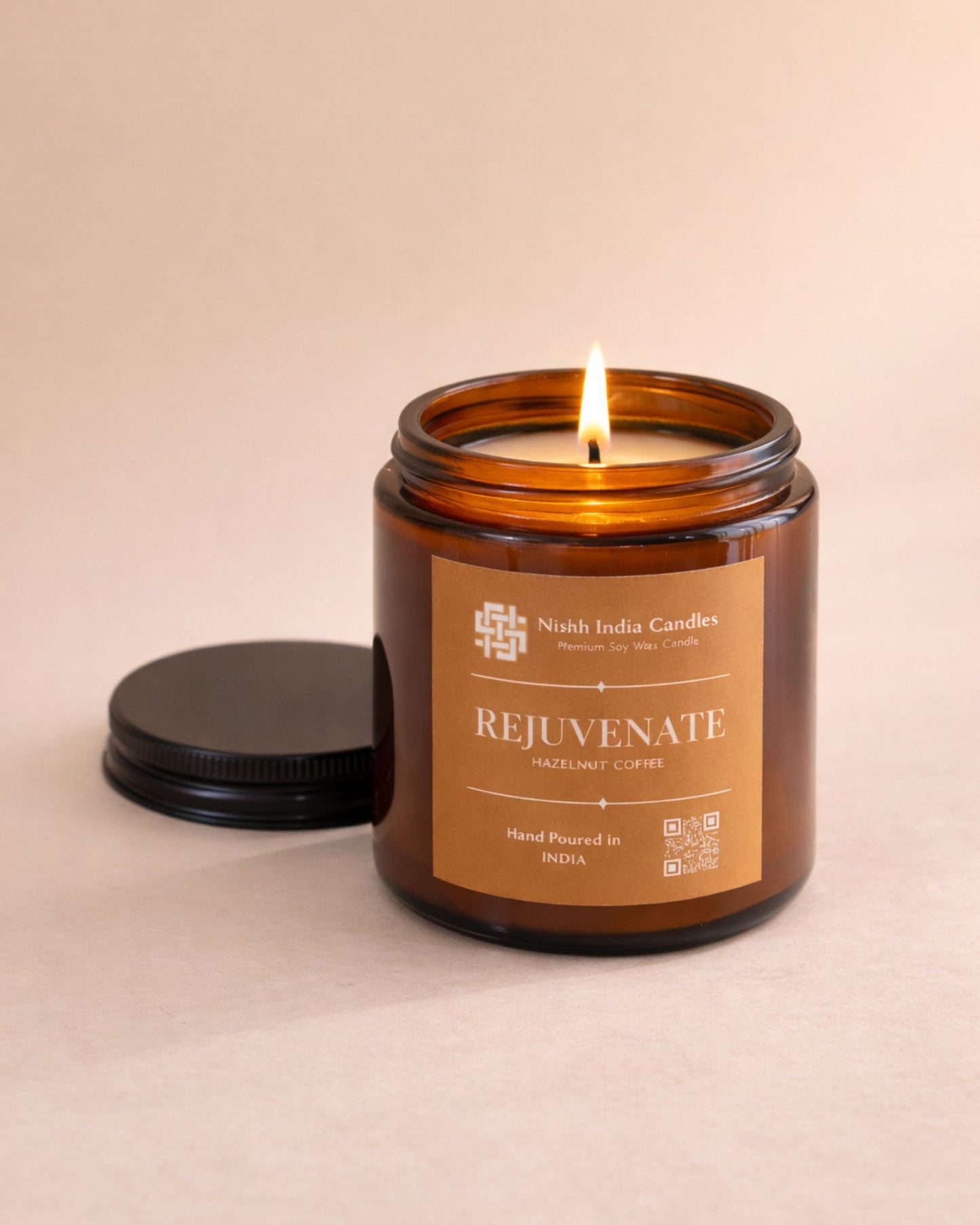 Amber candle jar labeled 'Rejuvenate' by Nishh India Candles on a beige background