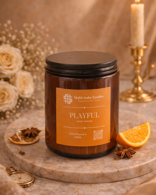 Nishh India Playful Sweet Orange hand poured soy wax candle in amber glass jar on clean neutral background for luxury home decor