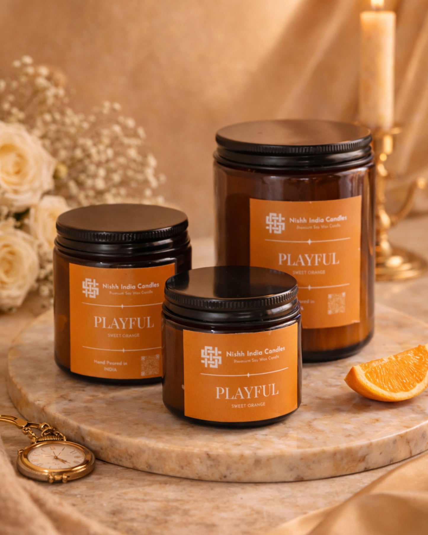 Lit Nishh India Sweet Orange soy wax candle in amber jar creating warm cozy ambience with soft beige decor and glowing background lights
